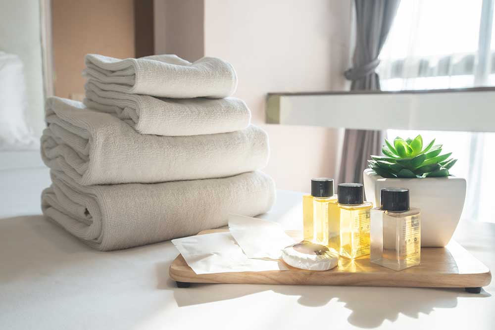 Set of hotel amenities (such as towels, shampoo, soap etc) on the bed. Hotel amenities is something of a premium nature provided in addition to the room when renting a room